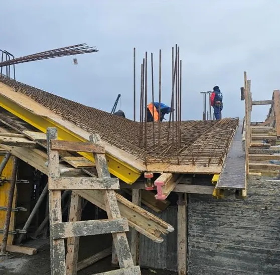 Șantierul ansamblului Mitropolit Varlaam din Iași: armături și cofraje pentru o placă de beton armat, cu muncitori pe placă
