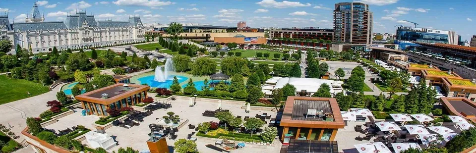 Vedere aeriană a complexului Palas Iași: grădinile cu fântână arteziană și pavilioanele, Palatul Culturii în stânga și clădirea-turn de birouri în fundal
