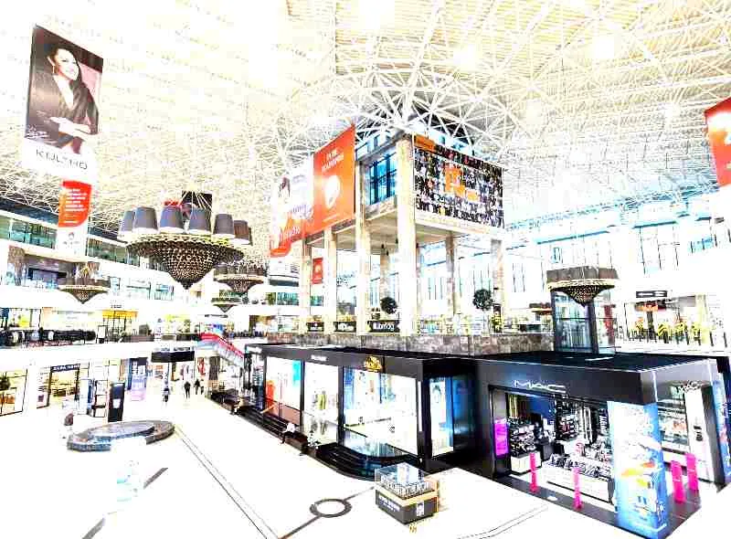 Interiorul centrului comercial Palas Iași, cu atriumul acoperit de cupola cu structură spațială, candelabre și magazine